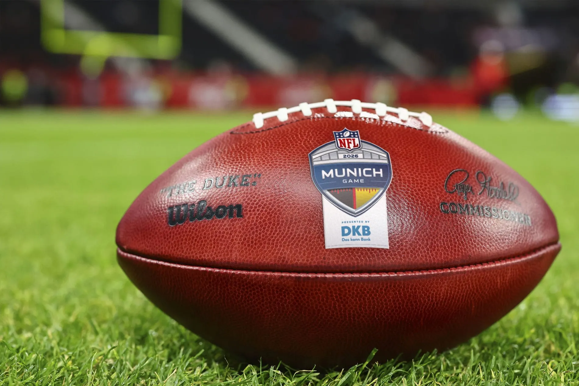 Ein Wilson-Football mit dem Logo des 2026 NFL Munich Game auf einem Rasen.